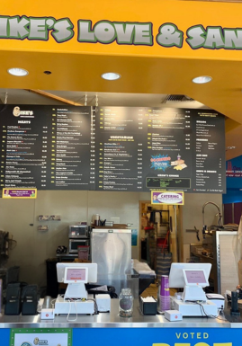 A staff member using a CAKE POS system at an Ike's Love and Sandwiches location.