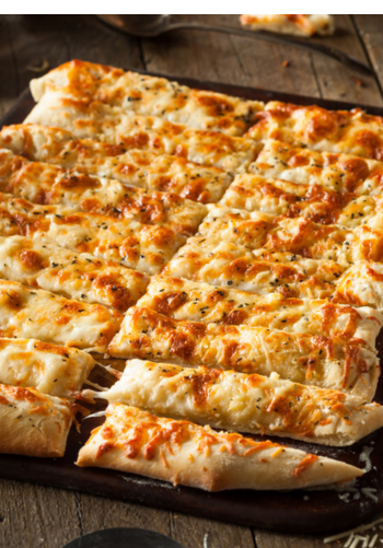 Several square slices of a Detroit-style pizza with a thick crust and cheese.