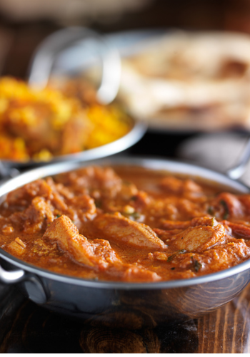A close-up of a bowl of a rich Indian curry dish.