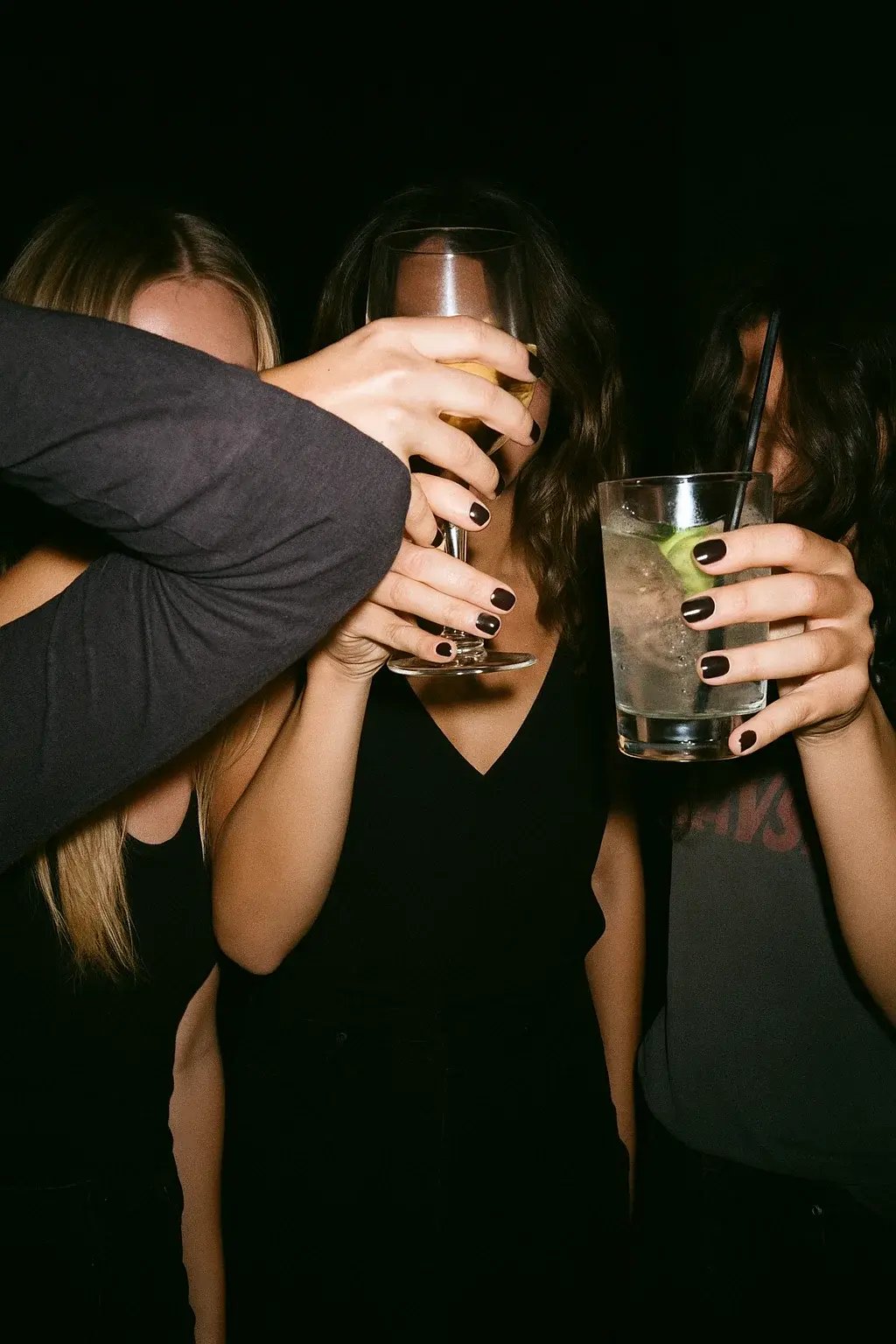A person holding two beer glasses in a toast, celebrating a night out at a bar.