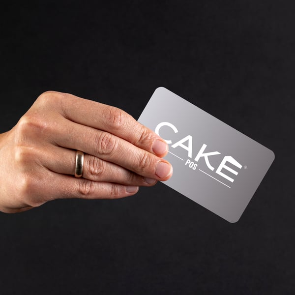 Hand holding CAKE POS gift card, a restaurant marketing tool to boost revenue, visibility, and customer loyalty.